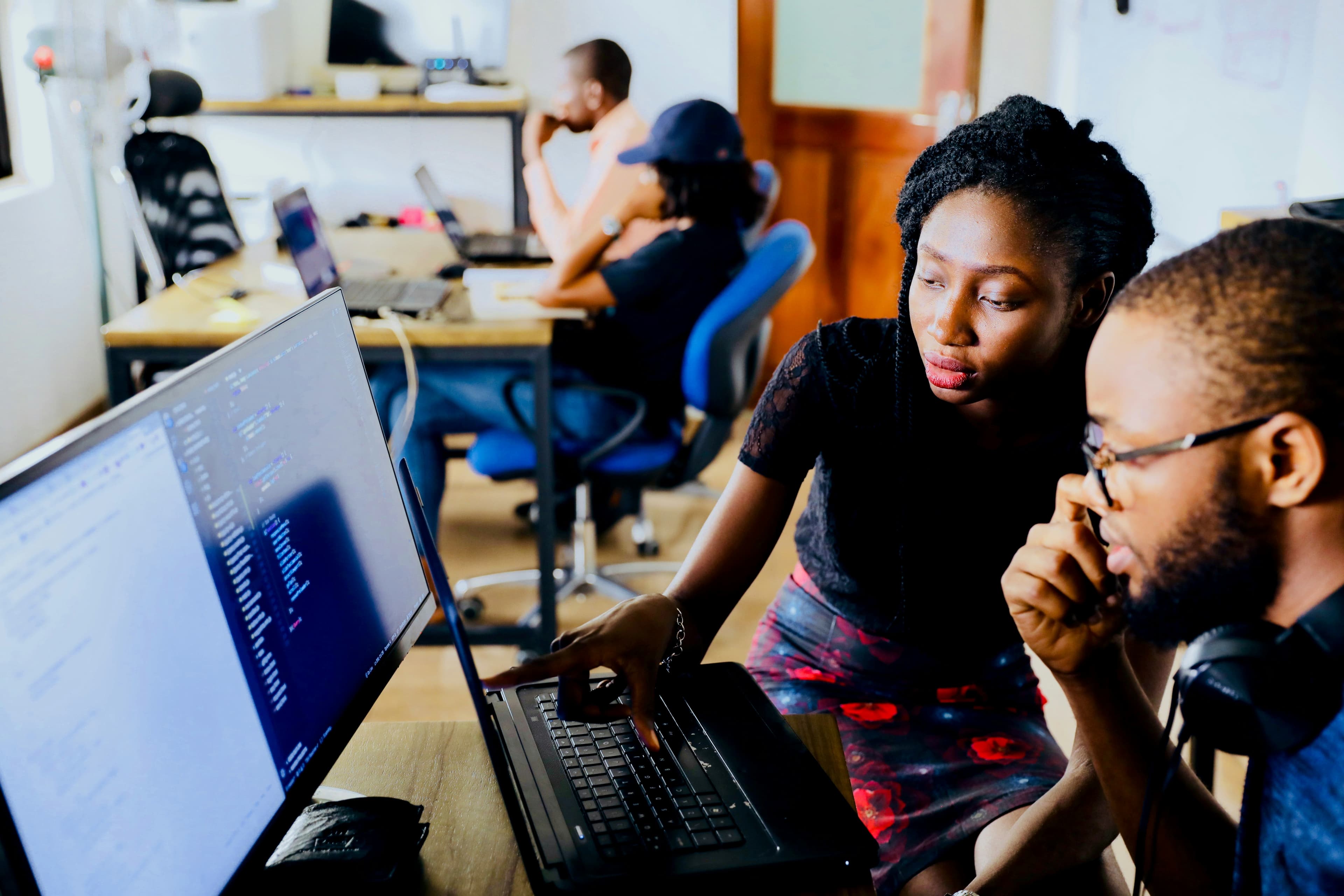 Photo — mentor reviewing a learner's project on screen